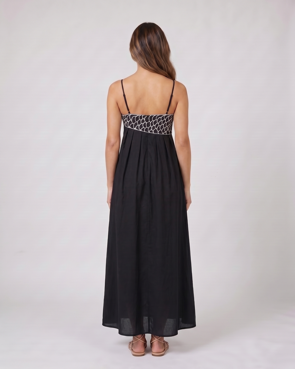 Back view of black sweetheart fish print maxi dress showing solid back with an embroidered waistband and side zipper closure