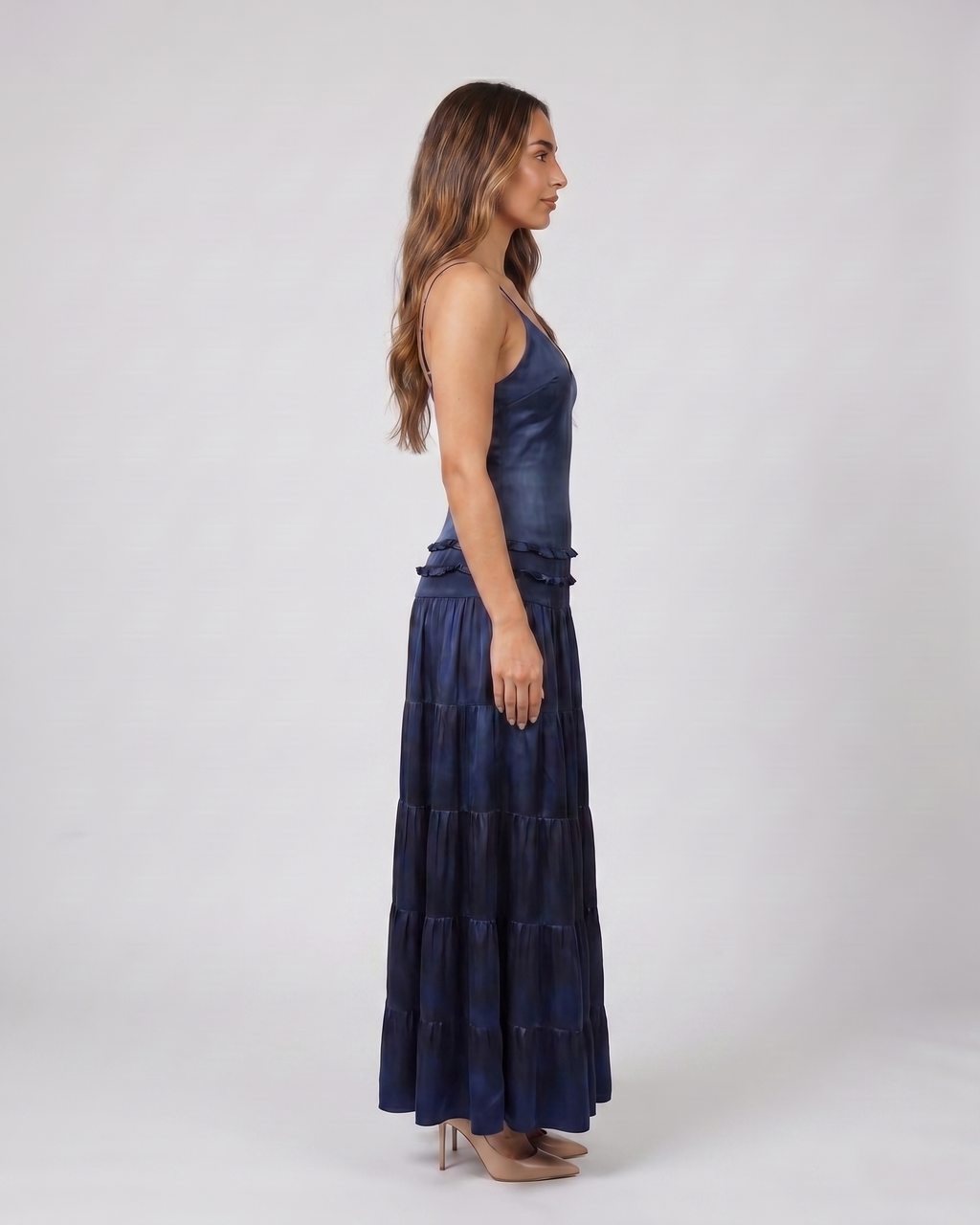 Side view of blue v neck spaghetti strap open back tiered maxi dress