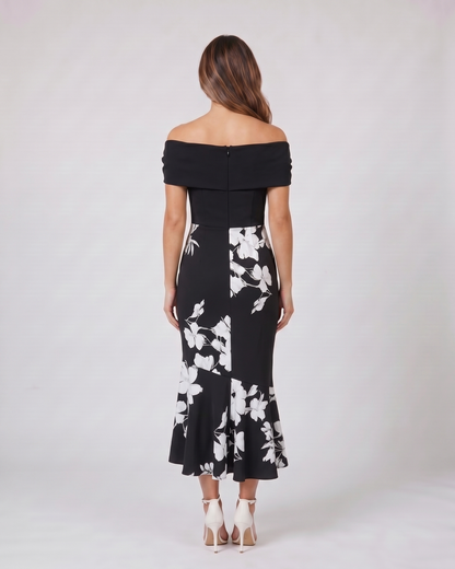 Back view of black wedding guest floral off shoulder midi dress showing solid back with zipper closure