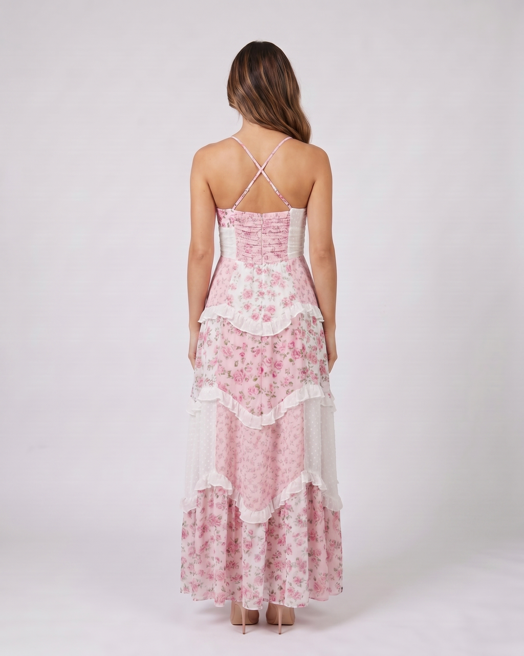 Back view of pink wedding guest floral v neck maxi dress showing open back with criss-cross X-straps and smocked upper back panel