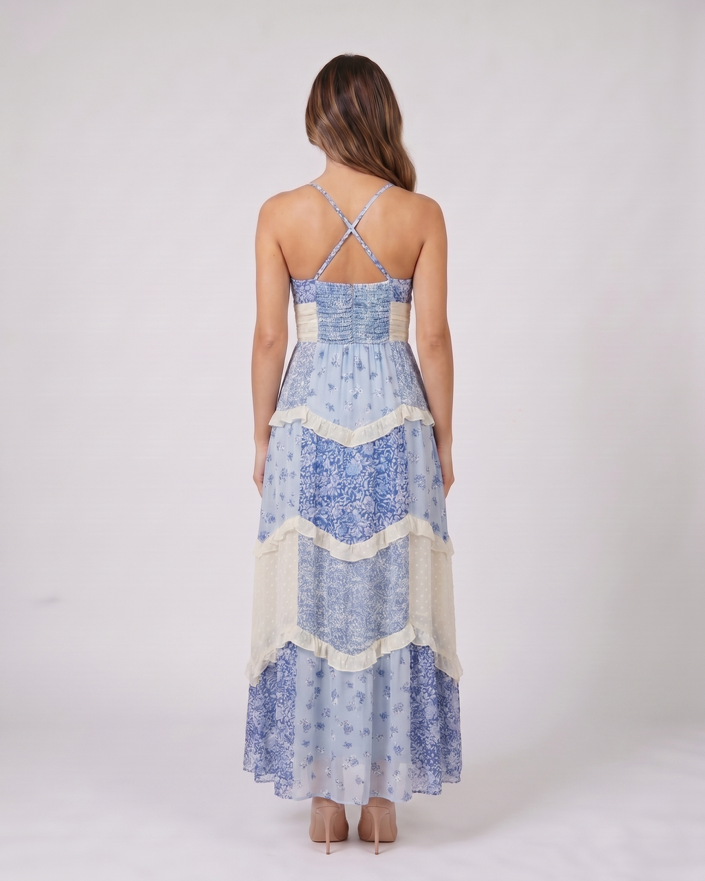 Back view of blue wedding guest floral v neck maxi dress showing open back with criss-cross X-straps and smocked upper back panel