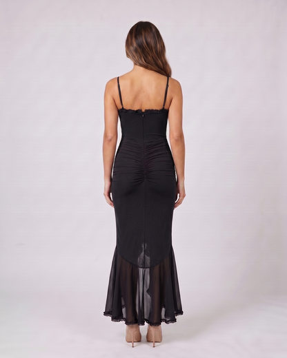 Back view of black wedding guest ruched sweetheart maxi dress showing solid back with center zipper closure