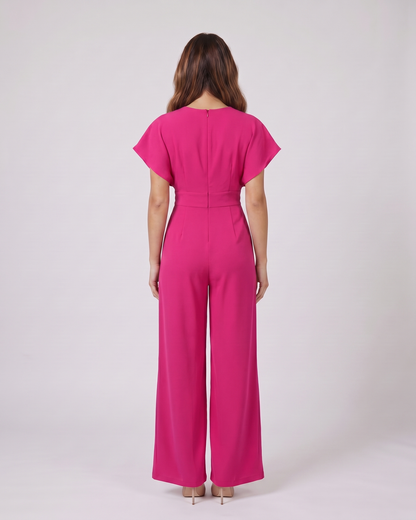 Back view of pink cocktail v neck flutter sleeve wide leg jumpsuit showing solid back with round neckline and center back zipper closure