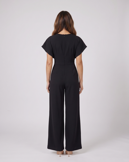 Back view of black cocktail v neck flutter sleeve wide leg jumpsuit showing solid back with round neckline and center back zipper closure