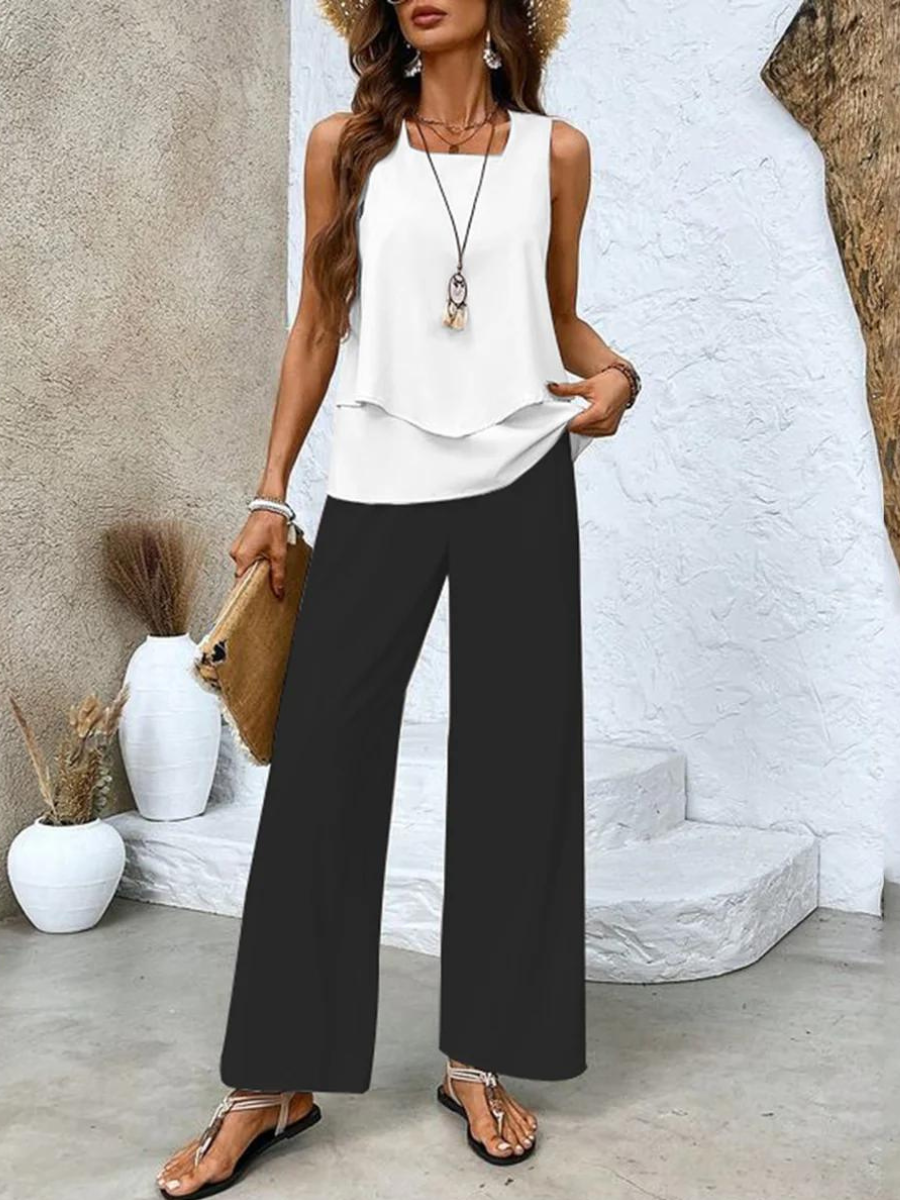 White sleeveless layered blouse with black wide leg pants front view