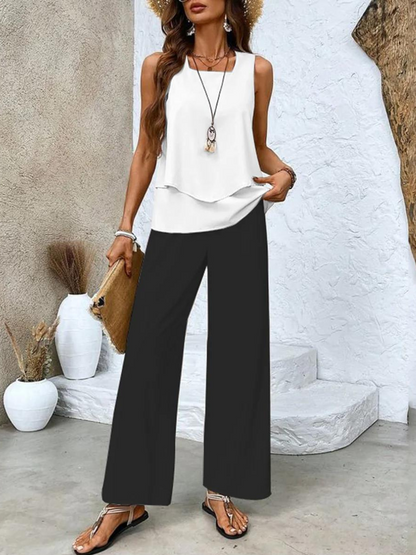 White sleeveless layered blouse with black wide leg pants front view