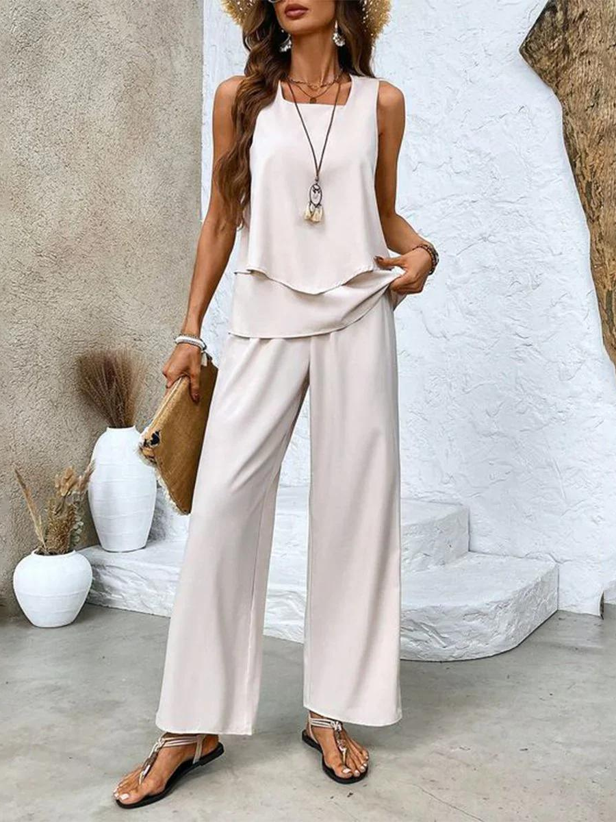 Cream sleeveless layered blouse with beige wide leg pants full length view