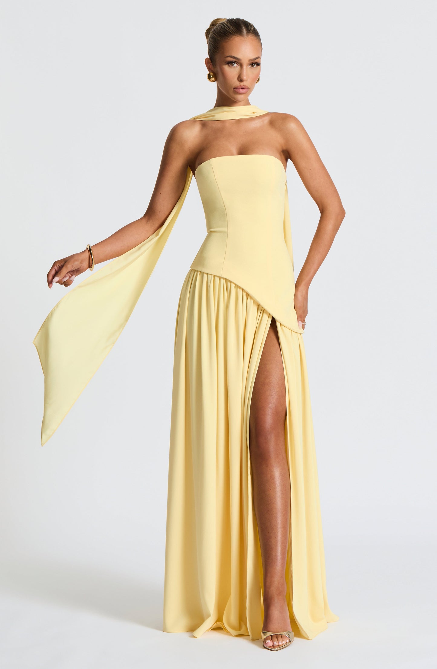 Pale yellow strapless maxi dress with flowing asymmetric waist and side drape