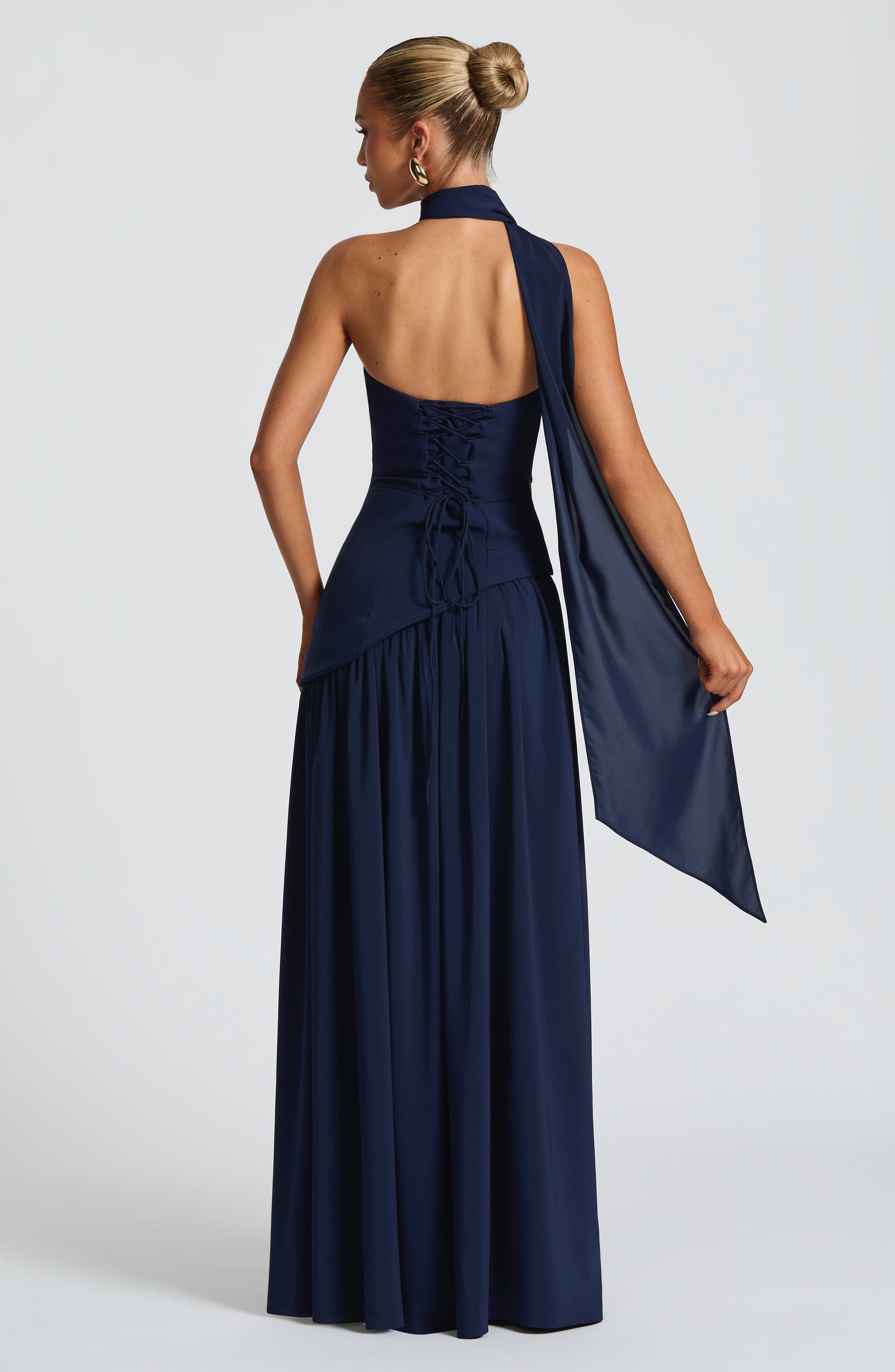 Navy halter strapless maxi dress back view with asymmetric waist and flowing skirt