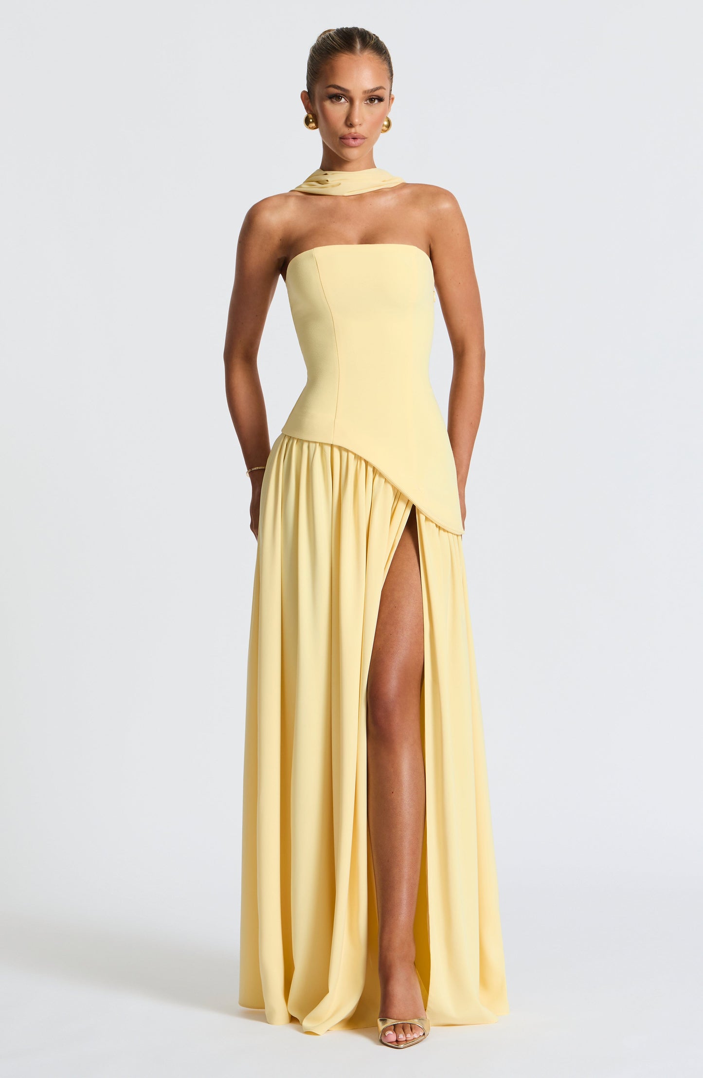 Pale yellow strapless maxi dress with diagonal asymmetric waist and high slit