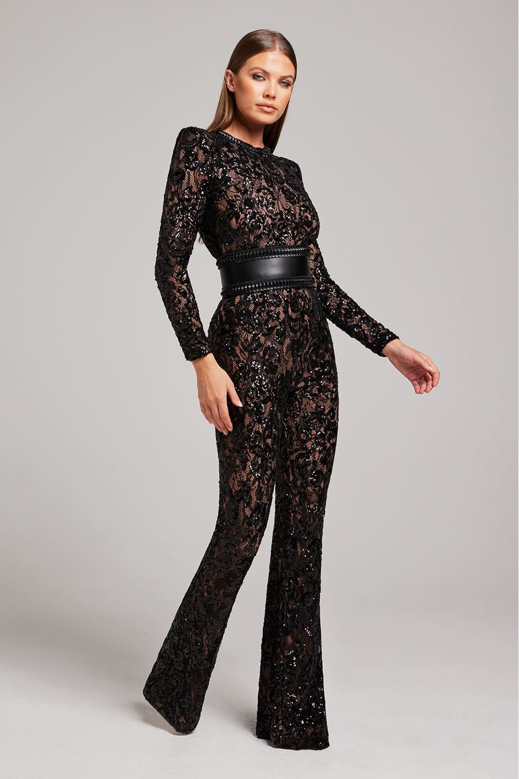 Side view of black sequin lace jumpsuit with long sleeves and flared pants