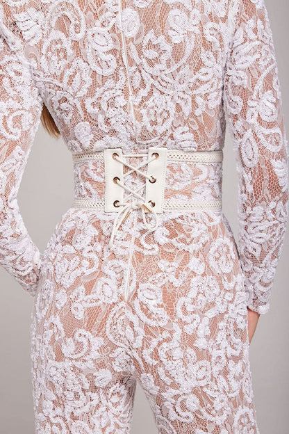Detail of cream lace-up belt and white lace fabric on wide leg jumpsuit