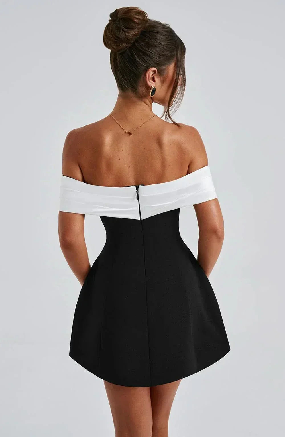 Rear view showing white off-shoulder neckline and black skirt