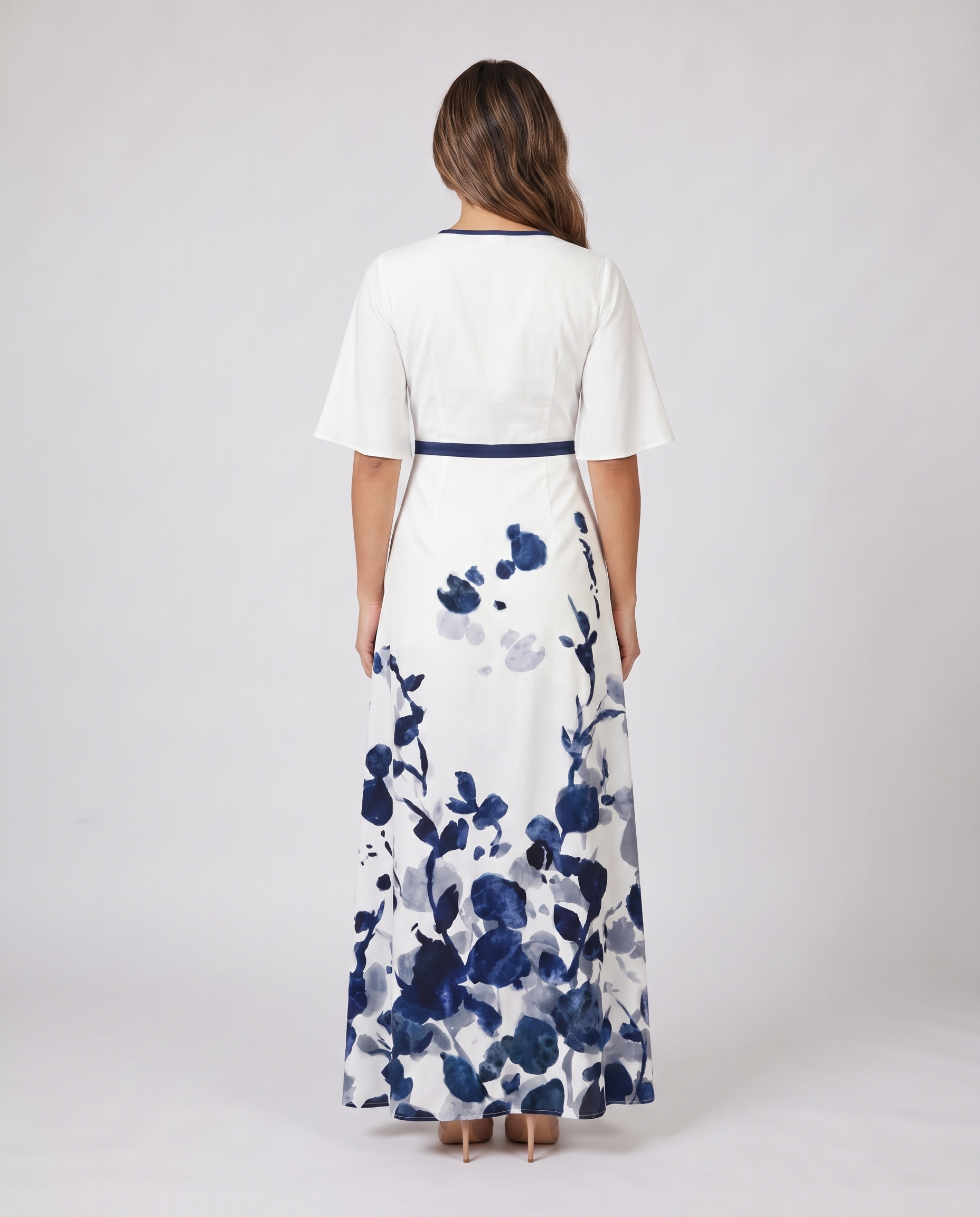 Back view of white wedding guest maxi dress with navy trim and floral print