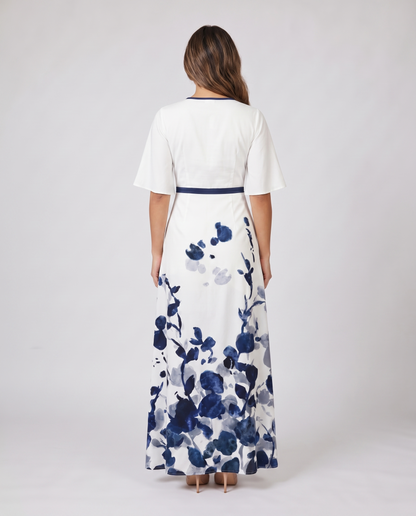 Back view of white wedding guest maxi dress with navy trim and floral print