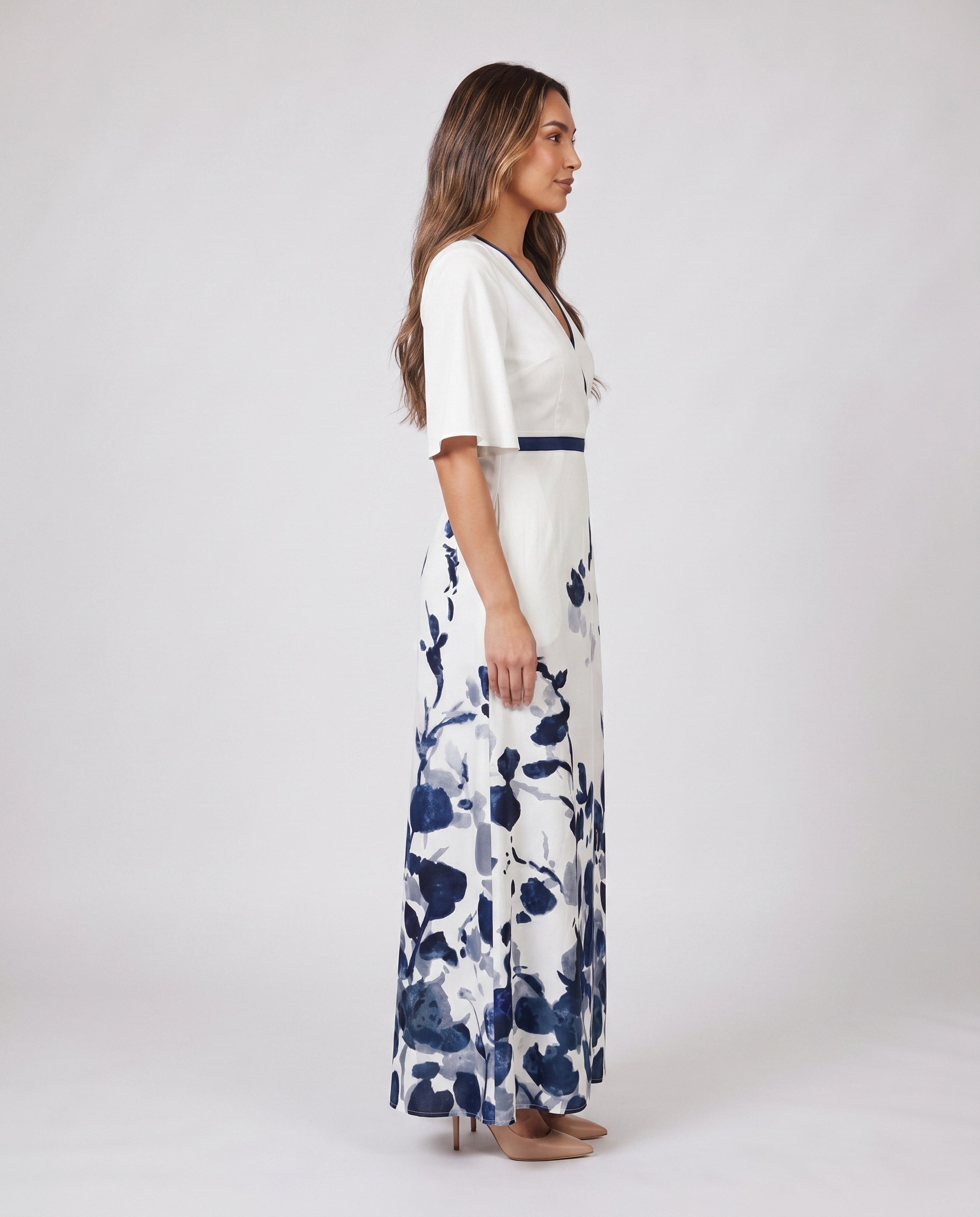 Side profile of white wedding guest maxi dress with navy trim and floral print
